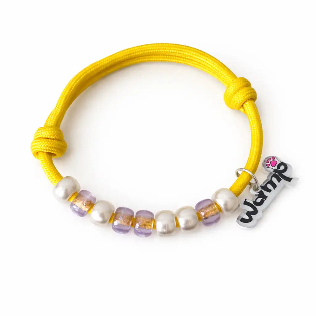 Yellow necklace with beaded charm on a white background