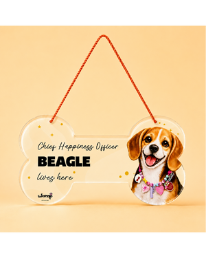 A bone-shaped clear acrylic hanging plaque with a red hanging rope, featuring the text 'Chief Happiness Officer BEAGLE lives here' and a printed beagle illustration on the right side, shown on a warm beige background.